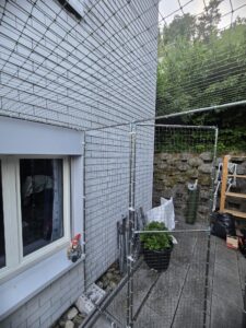 Sicherung für Katzen auf einer Terrasse als Freilauf für die Katzen / Tiere in Zürich. Schutz vor dem davonlaufen der Tiere. Eingebaute Türe in das Schutznetz.