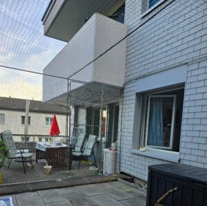 : Sicherheitsnetz auf einer Terrasse als Freilauf für die Katzen / Tiere. Schutz vor dem davonlaufen der Tiere. Eingebaute Türe in das Schutznetz.